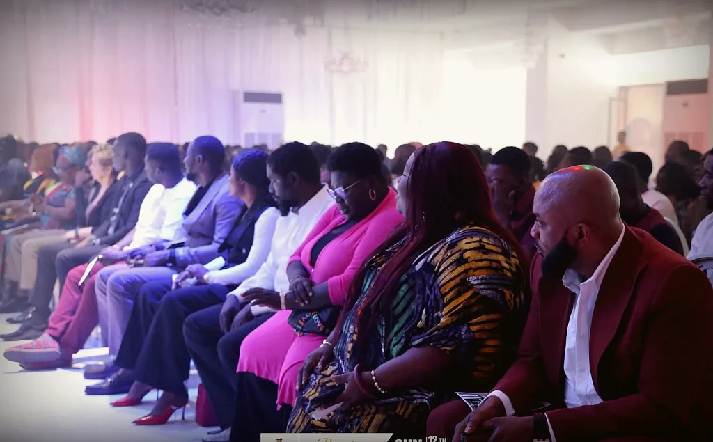 Congregation seated for a service, wide view from behind the crowd