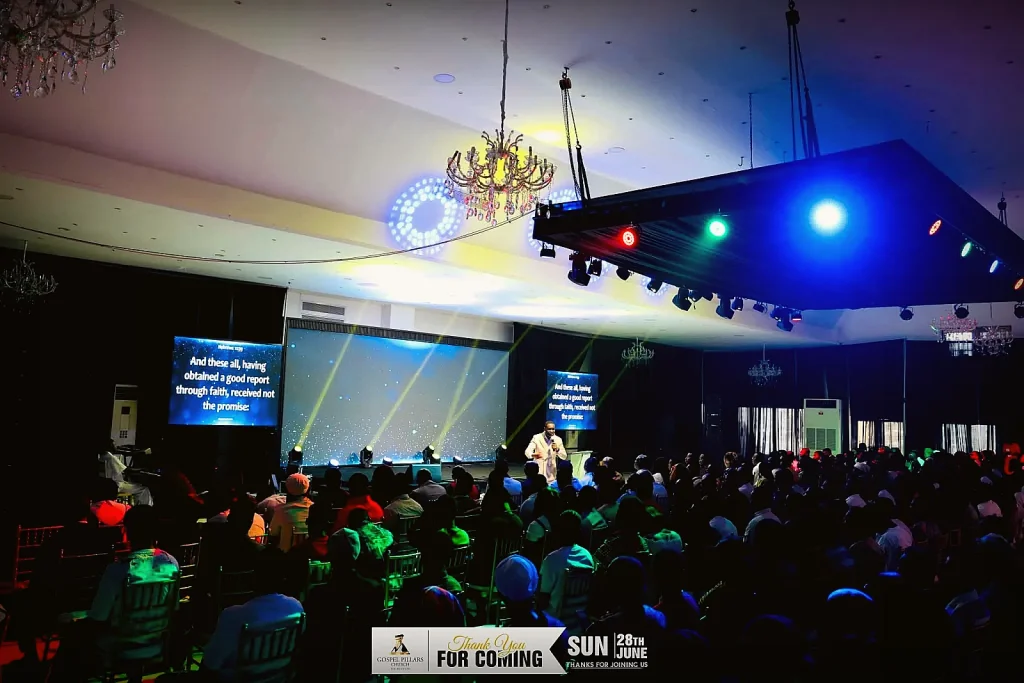 Wide view of the sanctuary during a service, chandeliers and stage lighting